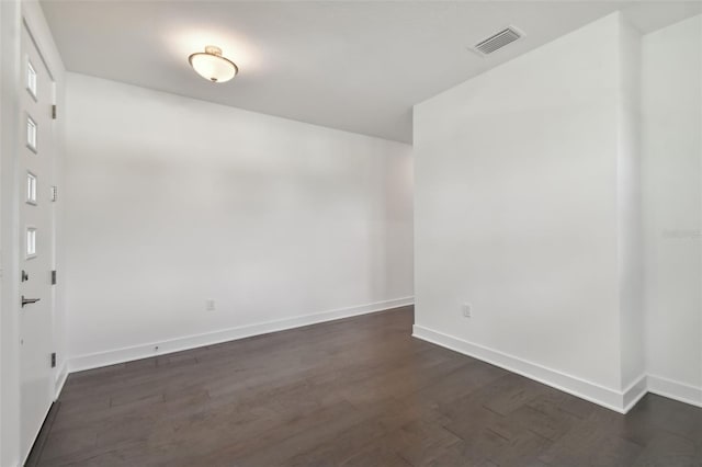 empty room with dark hardwood / wood-style flooring