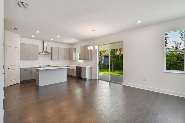 kitchen with gray cabinets, a healthy amount of sunlight, wall chimney range hood, and stainless steel appliances