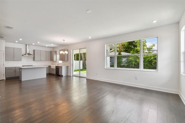 unfurnished living room featuring dark hardwood / wood-style floors, sink, and a chandelier