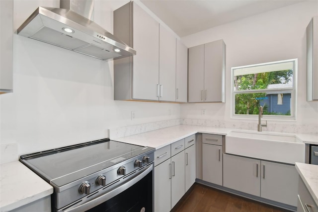 kitchen featuring gray cabinetry, stainless steel range with electric cooktop, sink, wall chimney exhaust hood, and dark hardwood / wood-style floors