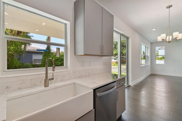 kitchen with gray cabinetry, dishwasher, light stone counters, and sink