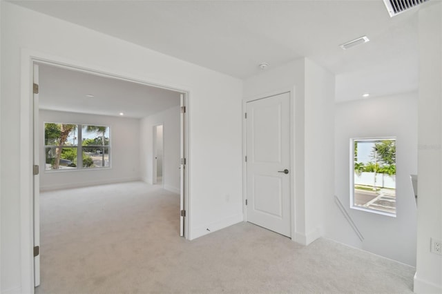 corridor featuring light colored carpet