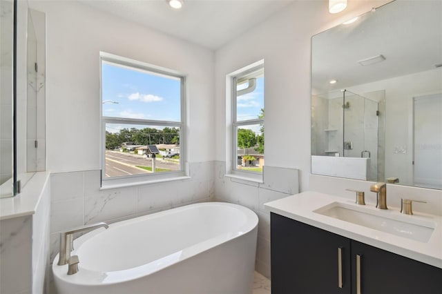 bathroom with vanity, tile walls, and plus walk in shower