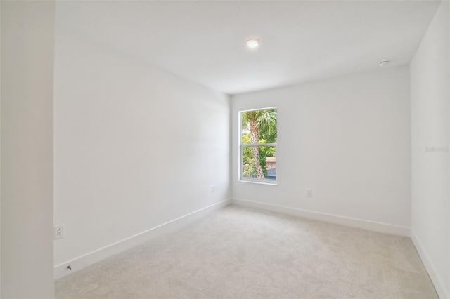 unfurnished room featuring light colored carpet