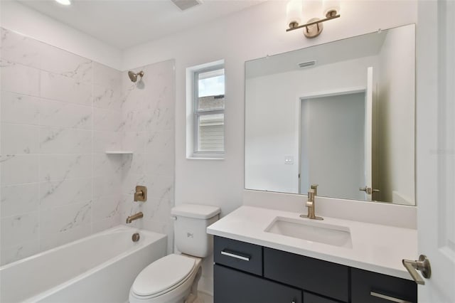 full bathroom featuring vanity, tiled shower / bath combo, and toilet