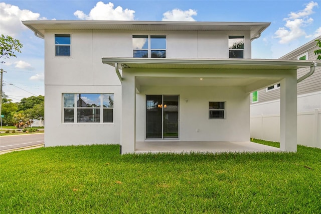 back of property with a patio area and a yard