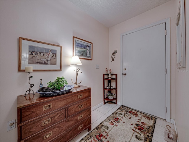 entryway featuring light tile patterned floors and a textured ceiling