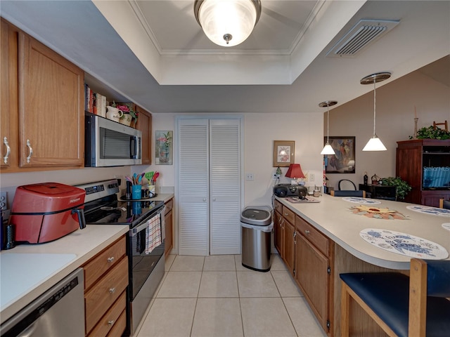 kitchen featuring crown molding, hanging light fixtures, light tile patterned floors, a raised ceiling, and stainless steel appliances