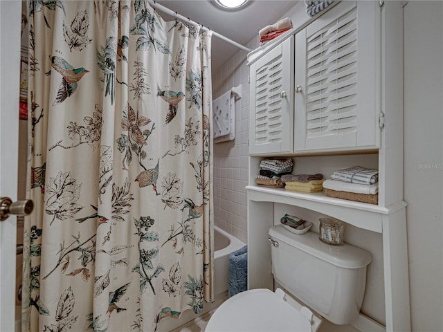 bathroom with shower / tub combo with curtain and toilet