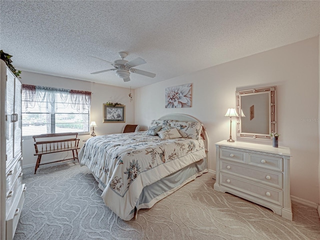 carpeted bedroom featuring ceiling fan and a textured ceiling