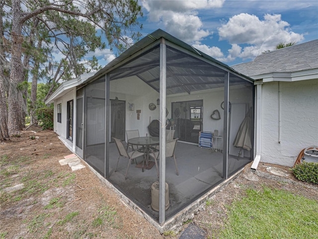 back of property featuring glass enclosure and a patio area