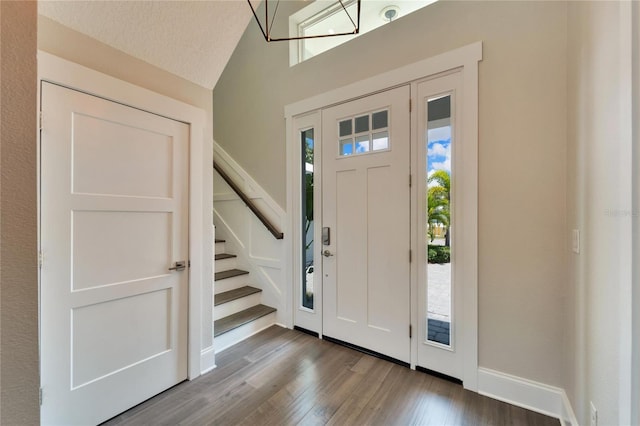 foyer entrance with hardwood / wood-style flooring and vaulted ceiling