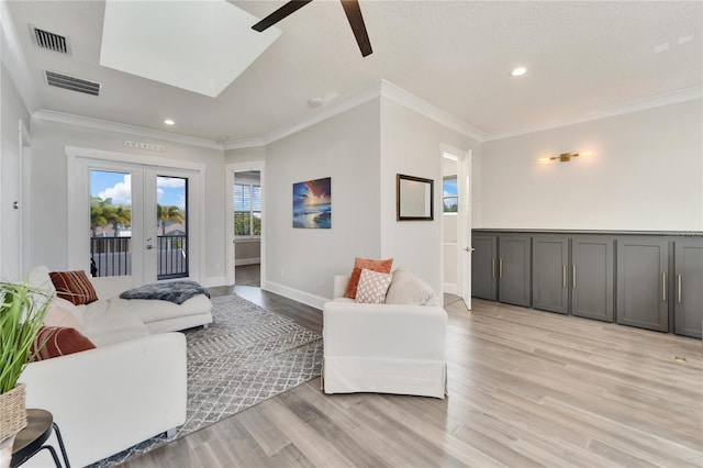 living room with light hardwood / wood-style floors, french doors, crown molding, and ceiling fan