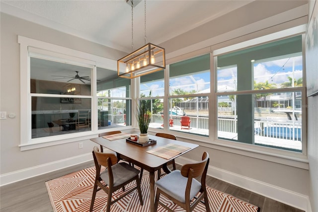 dining space featuring ceiling fan with notable chandelier and wood-type flooring