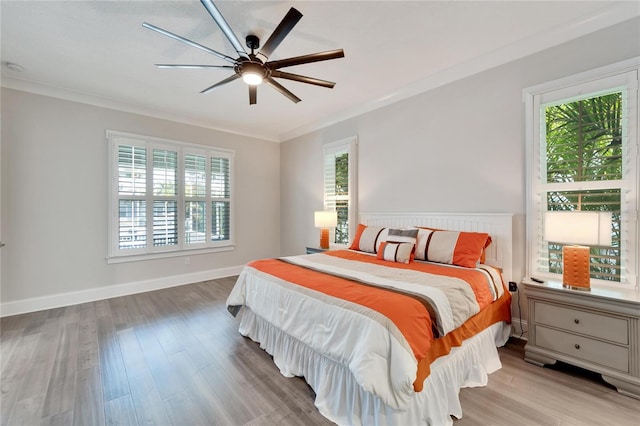 bedroom featuring ceiling fan, crown molding, and light wood-type flooring