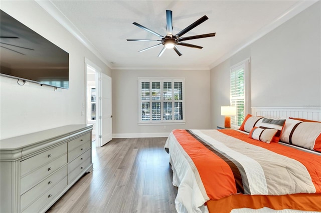 bedroom featuring hardwood / wood-style flooring, ornamental molding, multiple windows, and ceiling fan