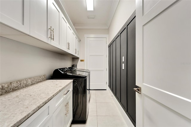 laundry room featuring washer and dryer, cabinets, light tile floors, and crown molding