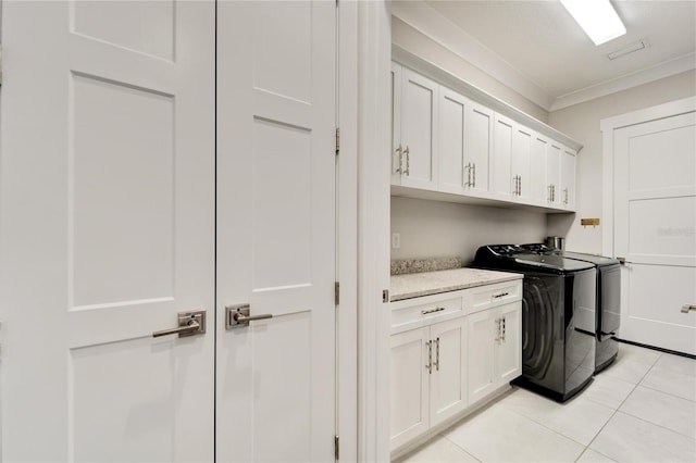 laundry room with cabinets, ornamental molding, washer and clothes dryer, and light tile floors