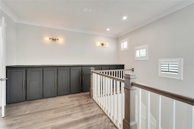 hall with light wood-type flooring and crown molding