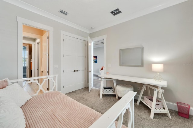 bedroom with ornamental molding, a closet, and carpet flooring