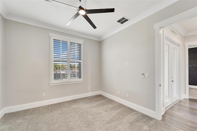 unfurnished room featuring light hardwood / wood-style floors, ornamental molding, and ceiling fan