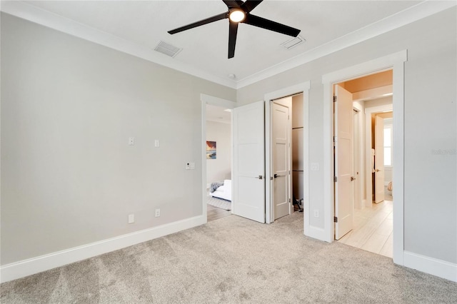 unfurnished bedroom featuring ornamental molding, ceiling fan, and light colored carpet