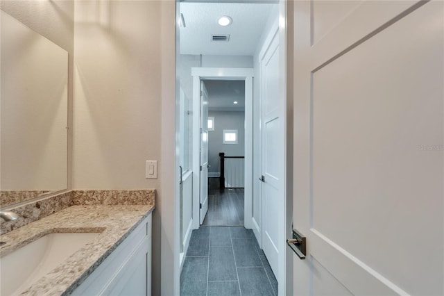 bathroom featuring tile flooring, a textured ceiling, and vanity