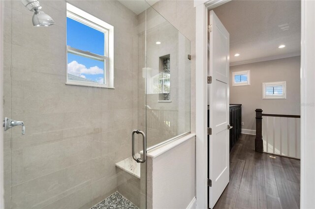 bathroom featuring a wealth of natural light, wood-type flooring, and walk in shower