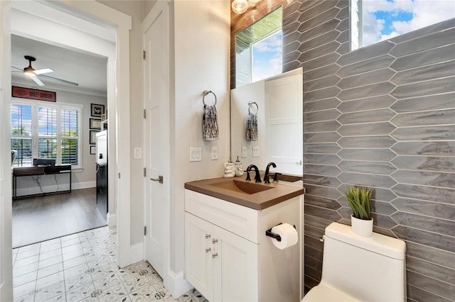 bathroom featuring plenty of natural light, toilet, ceiling fan, and oversized vanity