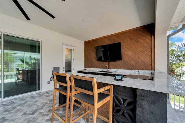 exterior space with tile floors, wooden walls, and light stone countertops