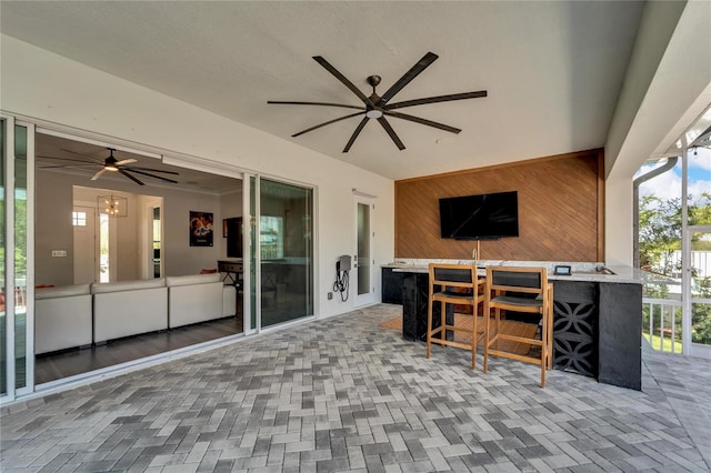 view of terrace with ceiling fan and an outdoor bar