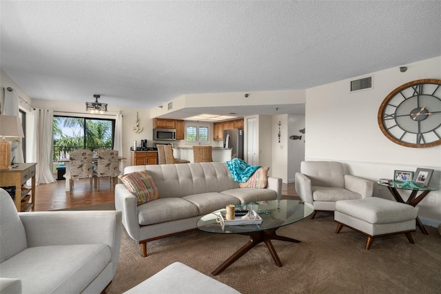 living room featuring wood-type flooring and a textured ceiling