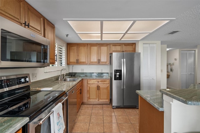 kitchen with sink, stainless steel appliances, and light tile floors