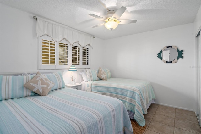 bedroom with tile flooring, ceiling fan, and a textured ceiling