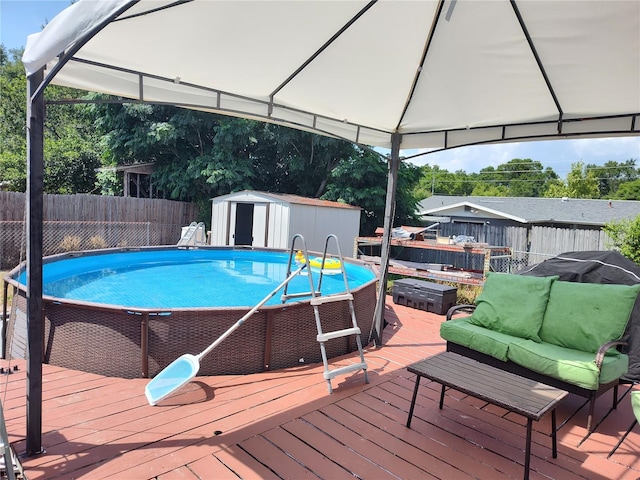 view of pool featuring a gazebo, a shed, and a wooden deck