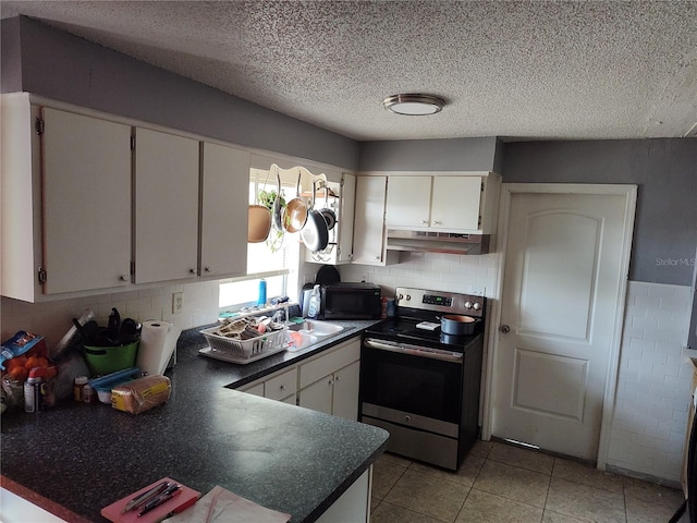 kitchen with white cabinets, stainless steel range with electric stovetop, tasteful backsplash, and light tile floors