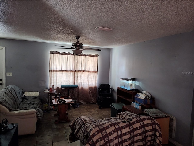 bedroom featuring ceiling fan, tile floors, and a textured ceiling