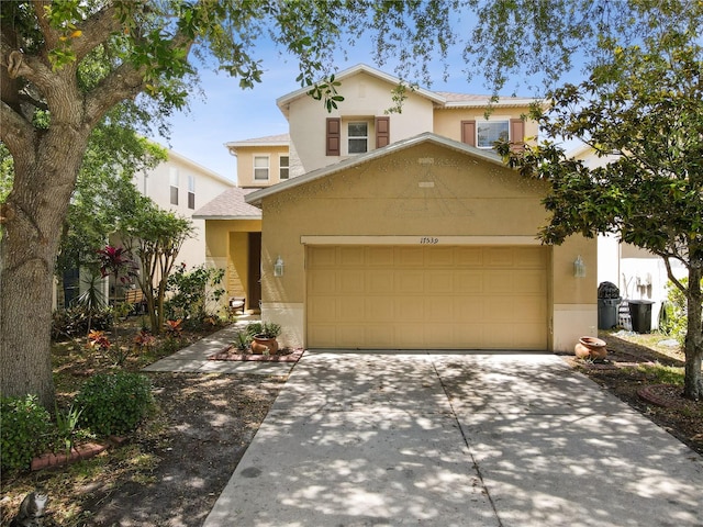 traditional home featuring driveway, a garage, and stucco siding