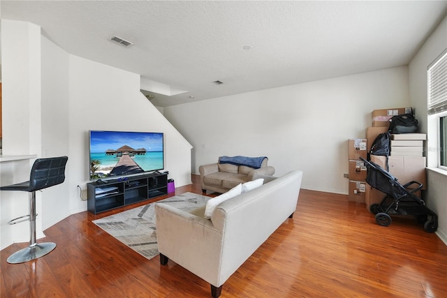 living room featuring hardwood / wood-style flooring and a textured ceiling