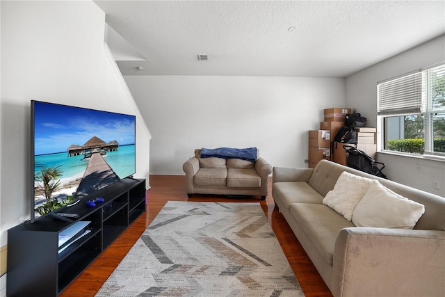 living room featuring visible vents, wood finished floors, and a textured ceiling