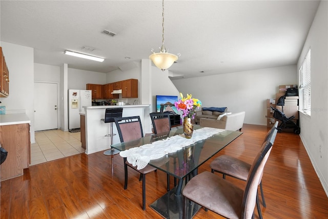 dining space featuring light wood finished floors and visible vents