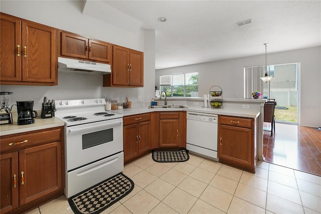 kitchen featuring white appliances, a textured ceiling, decorative light fixtures, kitchen peninsula, and sink