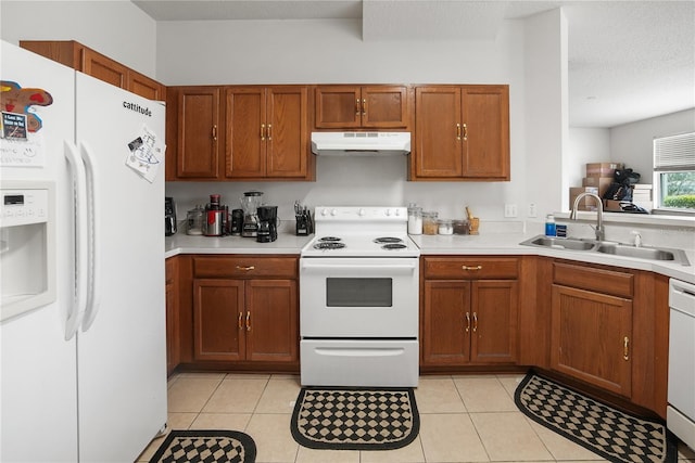 kitchen featuring white appliances, sink, light tile patterned flooring, and a textured ceiling