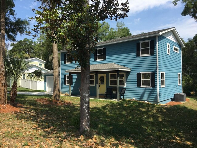 view of front facade featuring a garage, a front yard, and central air condition unit