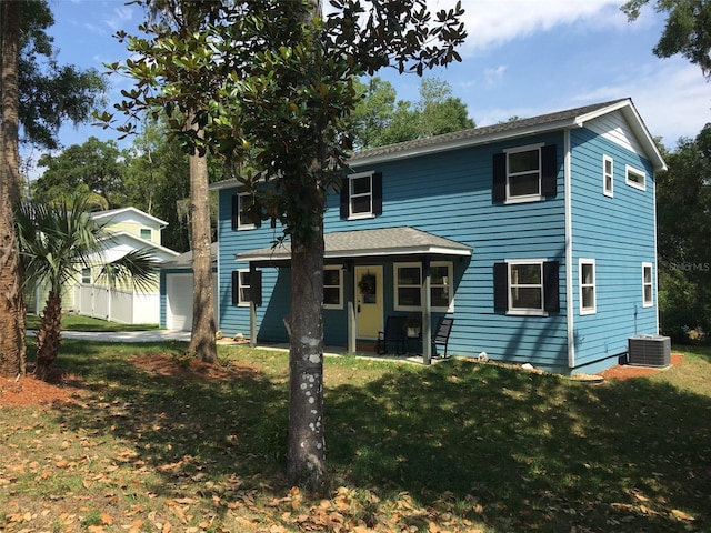 view of front of property with covered porch, central AC, a front yard, and an outdoor structure