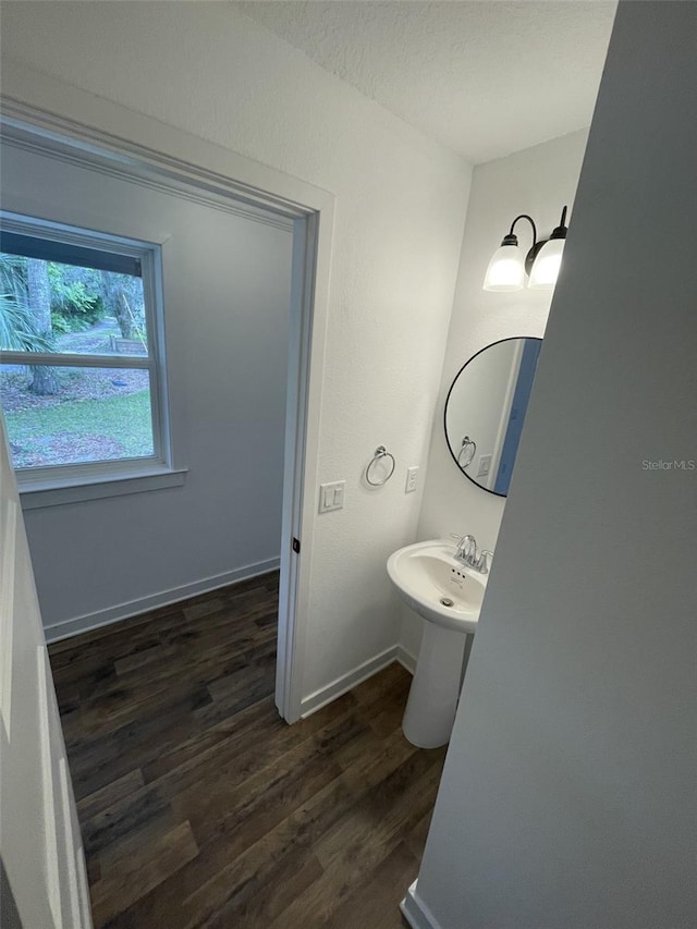 half bathroom featuring baseboards and wood finished floors