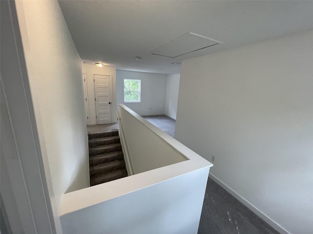 corridor featuring an upstairs landing and baseboards