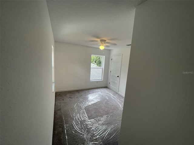 empty room with baseboards and a ceiling fan