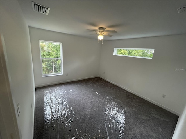 spare room with visible vents, ceiling fan, and baseboards