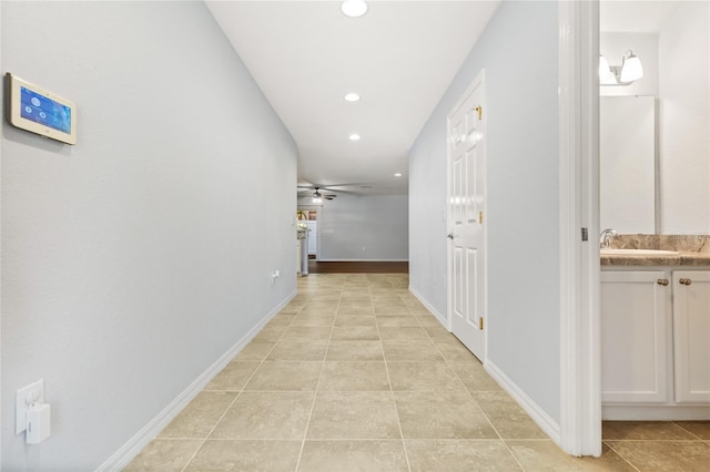 corridor with light tile patterned flooring and sink